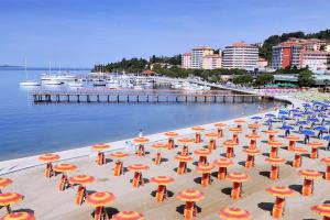 a group of umbrellas on a beach near the water at Floating House - SUNSET in Portorož