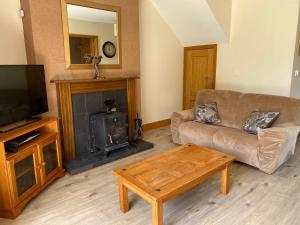 a living room with a couch and a fireplace at Your very own 19th hole!! in Tipperary