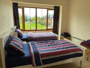 twee bedden in een kamer met een raam bij Your very own 19th hole!! in Tipperary