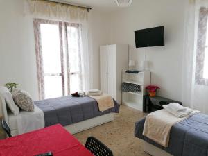 Sala de estar con 2 camas y TV en Giuseppe House, en Pisa