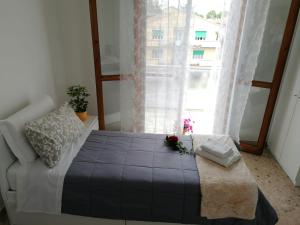 Un dormitorio con una cama y una ventana con flores. en Giuseppe House, en Pisa