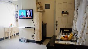 a living room with a television and a table with fruit at Tulip Apartment in Ormoc +16 photos