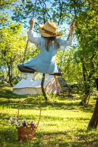 a girl in a hat swinging on a swing at Robinson Accommodation Freedom in Foli