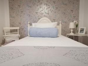 a bedroom with a white bed with a blue pillow at House in the Town Centre in Caminha