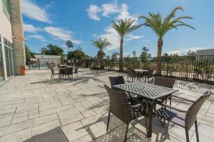 a patio with tables and chairs and palm trees at Holiday Inn Express & Suites Houston - North I45 Spring by IHG in Houston