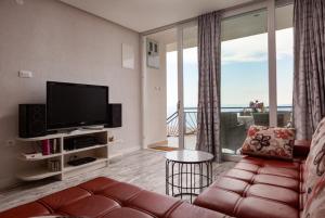 ein Wohnzimmer mit einem Sofa und einem Flachbild-TV in der Unterkunft Villa Marija in Bast
