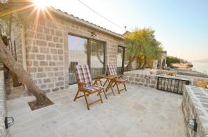 a patio with two chairs and a table at Leut Stone Residence in Tivat