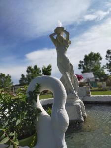 una estatua de una mujer y cisnes en una fuente en Villa Isabella en Marina di Grosseto