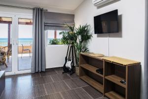 a living room with a flat screen tv on a wall at Level 3 Sea View Studio in Plános