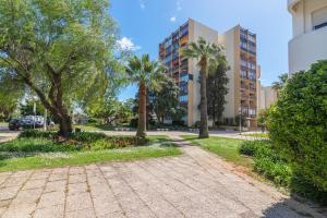 een park met palmbomen en een gebouw bij SUITEON7TH VILAMOURA THE BEST VIEW IN TOWN - 1Br in Quarteira