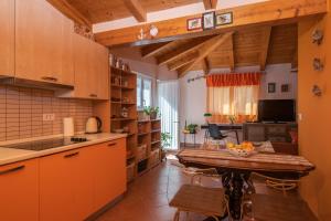 cocina con armarios naranjas y mesa de madera en Apartment Orange 29, en Rovinj
