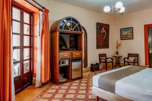 a bedroom with a bed and a tv in a room at Casa del Balam in Mérida