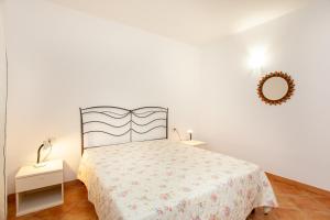 a white bedroom with a bed and a mirror at Appartamento Belvedere Citai in San Teodoro