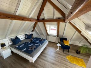 a bedroom with a bed and a chair in a attic at Ferienwohnung Schneider Friedrichshafen in Friedrichshafen