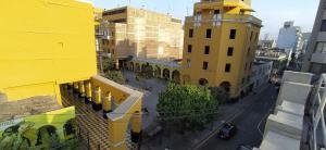 Santa Rosa Apartotel- Centro Histórico في ليما: اطلالة على مبنى اصفر وشارع