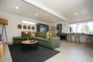 a living room with a green couch and a kitchen at Rubiaceae in Lorraine