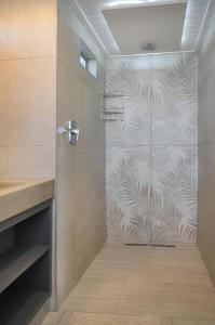 a shower with a glass door in a bathroom at Rubiaceae in Lorraine