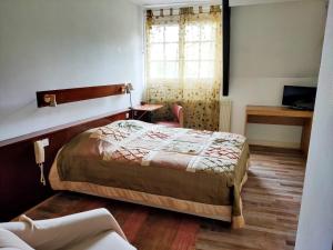 1 dormitorio con cama, escritorio y ventana en Auberge du val d’ouche, en Bligny-sur-Ouche
