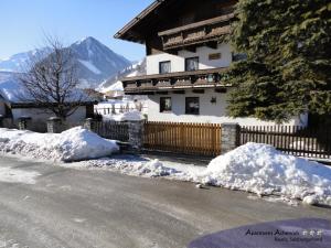 a house with snow on the side of the road at Apartmenthaus Achenruh in Rauris