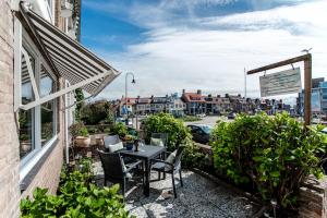 eine Terrasse mit einem Tisch und Stühlen auf dem Balkon in der Unterkunft Appartement en Studio Papillon in Zandvoort