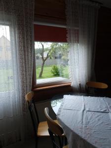 a dining room with a table and a window at Kāpas in Jūrkalne