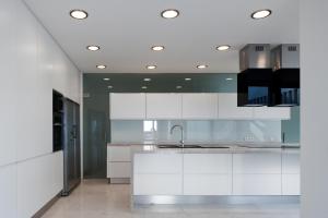a kitchen with white cabinets and a sink at Spacious sunset Villa with breathtaking view in Portimão