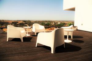 a group of white chairs and tables on a deck at Spacious sunset Villa with breathtaking view in Portimão