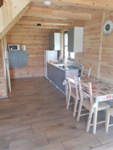 a kitchen with a table and chairs in a cabin at Gucio2 in Zwierzyniec