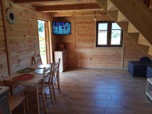 a dining room in a log cabin with a table and chairs at Gucio2 in Zwierzyniec