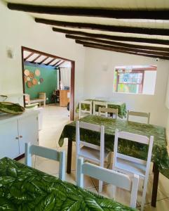 uma sala de jantar com uma mesa verde e cadeiras em Pousada dos Contos em Paraty