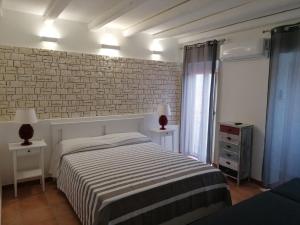 a bedroom with a bed and a brick wall at MOLO 78 Case Vacanze in Cefalù