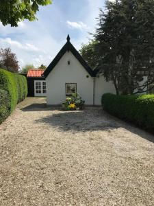 a small white house with a black roof at Vlasoven loft in Noordwijkerhout