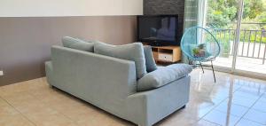 uma sala de estar com um sofá e uma televisão em Gîte " La Petite Compsoise " em Comps