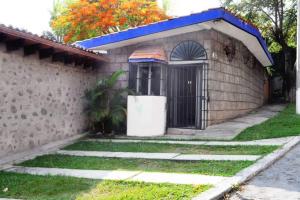 a building with a door and a grass yard at Departamento en Lomas de Cuernavaca con Aire Acond in Temixco