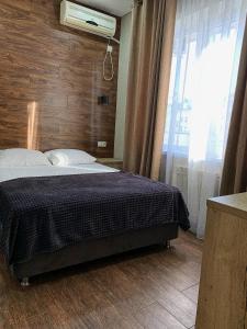 um quarto com uma cama e uma grande janela em Ambassador Guest House em Lazarevskoye