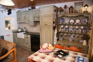 a kitchen with a table with a baby sitting on it at Cobblers Cottage Creggan in Greencastle