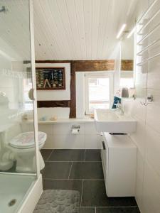 a white bathroom with a sink and a toilet at Gartenidyll Insel Rügen Poppelvitz bei Altefähr in Altefähr