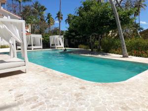 a pool with a chair and a person in the water at V&V Beach House in Punta Cana