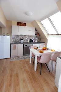 uma cozinha com uma mesa branca e um frigorífico branco em Lazur Sunrise em Burgas