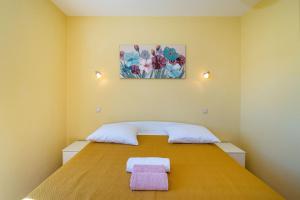 a bedroom with a bed with two towels on it at Villa Matea - heated pool, peace, view in Pridraga +40 photos