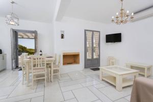 a white living room with a table and a fireplace at Infinity Blue - Villa B in Kampos Paros