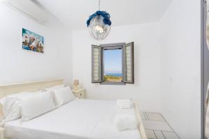 a white bedroom with a bed and a window at Infinity Blue - Villa B in Kampos Paros +12 photos