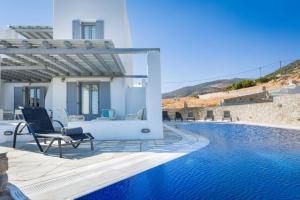 een villa met een zwembad en een patio met stoelen bij Infinity Blue in Kampos Paros