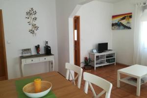 a kitchen and dining room with a table and chairs at Casa das Flores in Vila do Bispo