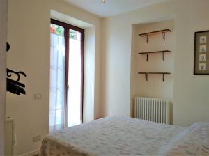 1 dormitorio con cama y ventana en La Verbanella A en Ghiffa