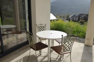 una mesa blanca y sillas en un balcón con vistas en Gîte Camdeborde 2 personnes au cœur du village de Laruns, en Laruns