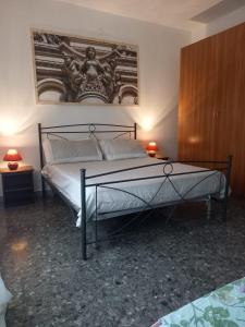 a bedroom with a bed and a painting on the wall at baia verde appartamento 150 m dal mare in Gallipoli
