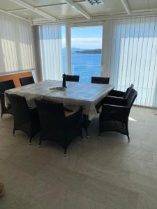 un comedor con mesa y sillas y el océano en Villa Desiree en Prizba