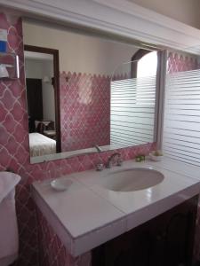 a bathroom with a sink and a mirror at Hotel Belle Vue in Le Lavandou