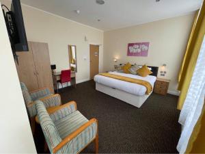 a large hotel room with a bed and a couch at Elsinore Hotel Llandudno in Llandudno